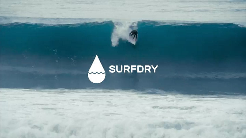 Surfer riding a wave with Surfdry logo overlay